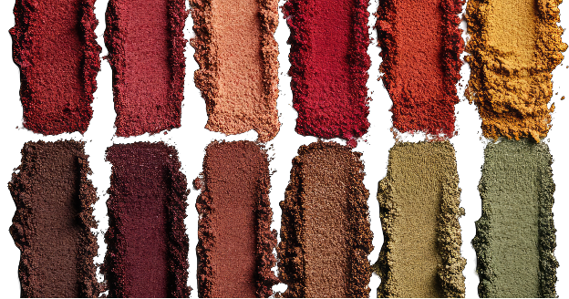 Twelve swatches of eyeshadow powder in burgundy, scarlet, tan, red, burnt orange, mustard yellow, coffee brown, maroon, clay red, bronze, olive green, and moss green